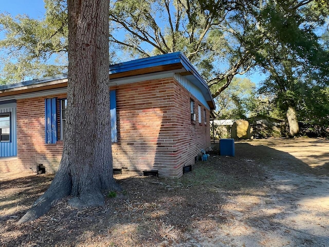 view of property exterior featuring crawl space and brick siding