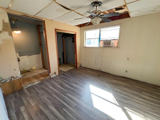 unfurnished bedroom featuring ceiling fan, a closet, cooling unit, and wood finished floors