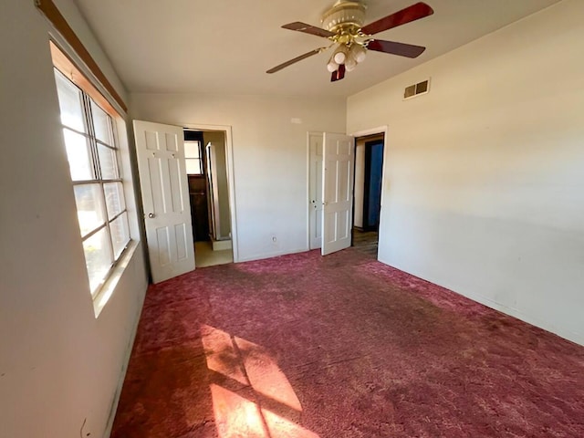 unfurnished bedroom featuring a ceiling fan, carpet, and visible vents