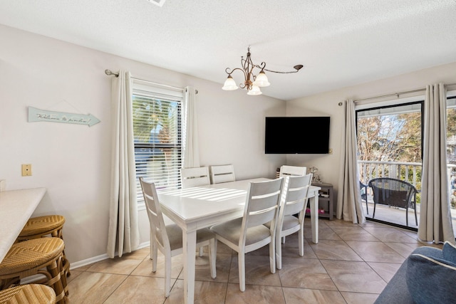 dining room with light tile patterned floors, baseboards, a textured ceiling, and an inviting chandelier