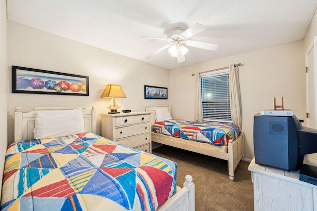 carpeted bedroom featuring a textured ceiling, baseboards, and ceiling fan