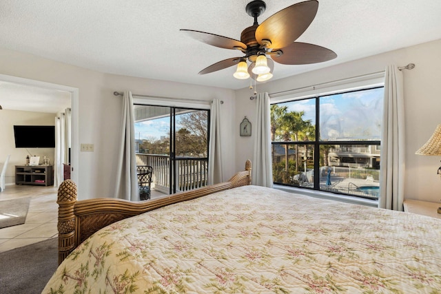 bedroom featuring ceiling fan, a textured ceiling, and access to exterior