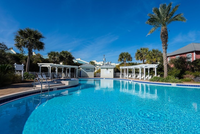 pool featuring an outbuilding, a patio area, fence, and a pergola