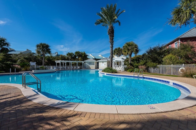 pool featuring an outbuilding, a patio area, fence, and a pergola