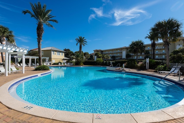 community pool featuring fence, a pergola, and a patio