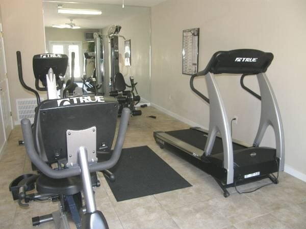 exercise area with visible vents, ceiling fan, and baseboards