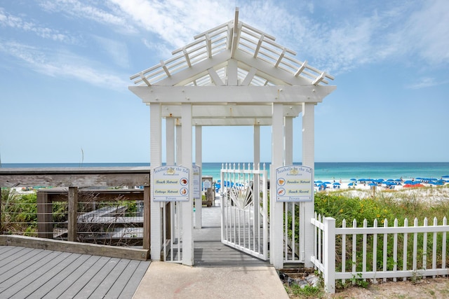 view of property's community with a view of the beach, a water view, and fence