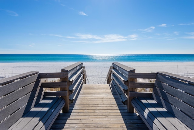 view of community with a water view and a beach view