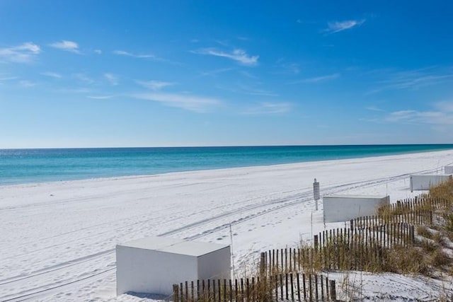 view of water feature featuring fence and a view of the beach