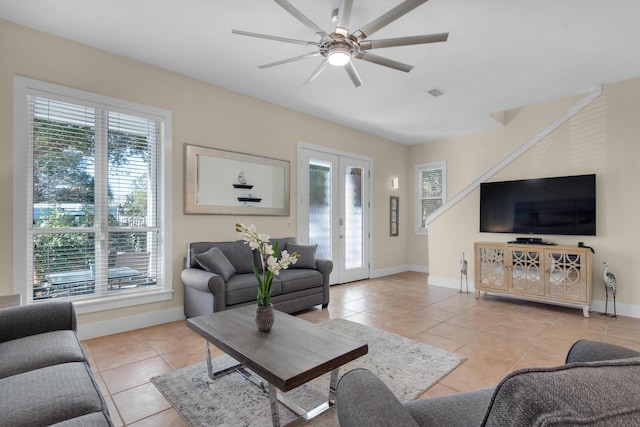 living room with light tile patterned floors, visible vents, baseboards, a ceiling fan, and french doors