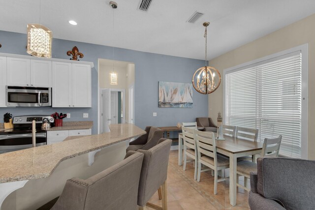 kitchen with white cabinets, light stone countertops, visible vents, and stainless steel appliances