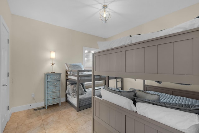 bedroom with light tile patterned floors and baseboards