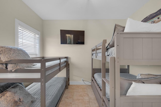 bedroom with baseboards and light tile patterned flooring