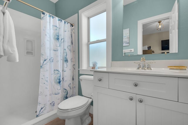 bathroom with toilet, curtained shower, and vanity