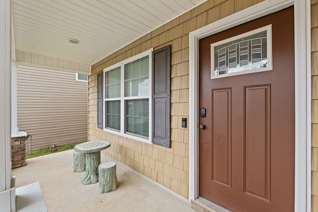 view of exterior entry featuring covered porch