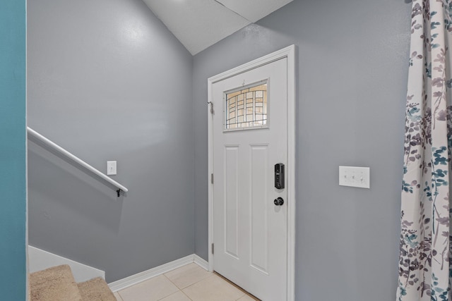 entrance foyer featuring stairs, baseboards, and light tile patterned flooring