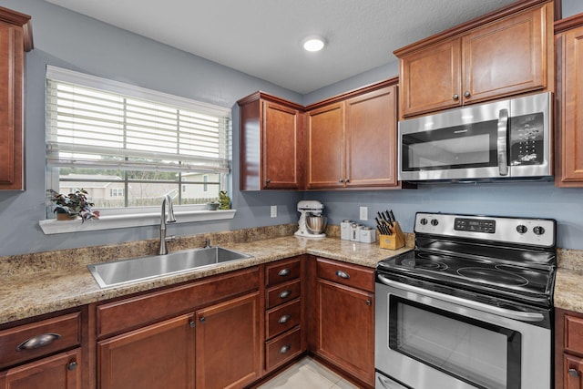 kitchen featuring appliances with stainless steel finishes, light countertops, and a sink