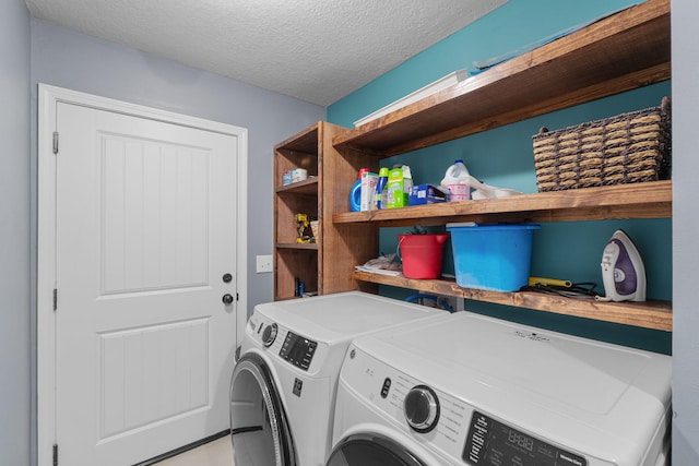 washroom with laundry area, a textured ceiling, and independent washer and dryer