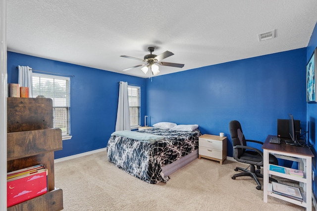 bedroom featuring a textured ceiling, ceiling fan, visible vents, baseboards, and carpet