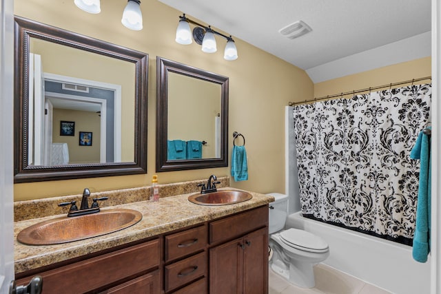 bathroom featuring toilet, double vanity, a sink, and visible vents