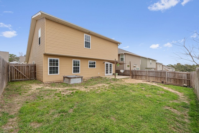 back of house with french doors, a patio area, a yard, and a fenced backyard