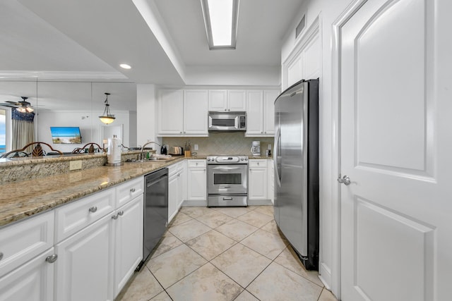 kitchen featuring stainless steel appliances, backsplash, a ceiling fan, white cabinets, and a sink