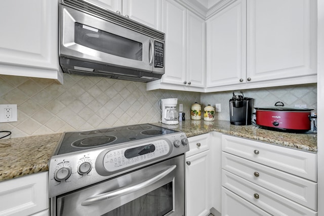 kitchen featuring appliances with stainless steel finishes, white cabinets, and tasteful backsplash