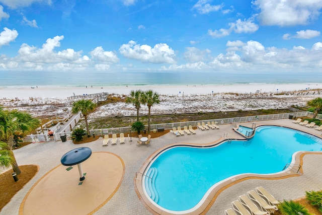 pool featuring a view of the beach, a water view, and a patio