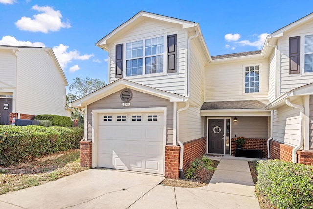 view of front of house featuring concrete driveway, brick siding, and an attached garage