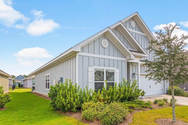 view of front of home with driveway, an attached garage, a front lawn, and board and batten siding