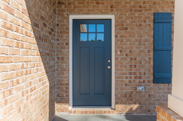 property entrance featuring brick siding