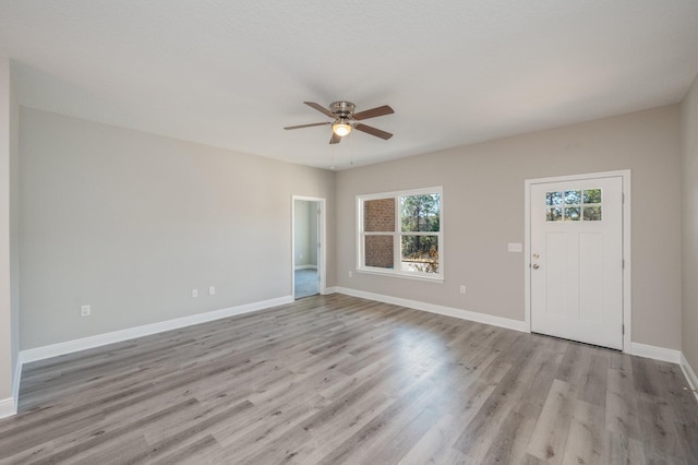 interior space with ceiling fan, light wood-style flooring, and baseboards