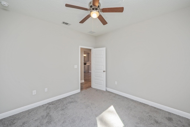 unfurnished bedroom featuring carpet floors, visible vents, a ceiling fan, a textured ceiling, and baseboards