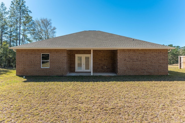 back of house featuring a yard, brick siding, and french doors