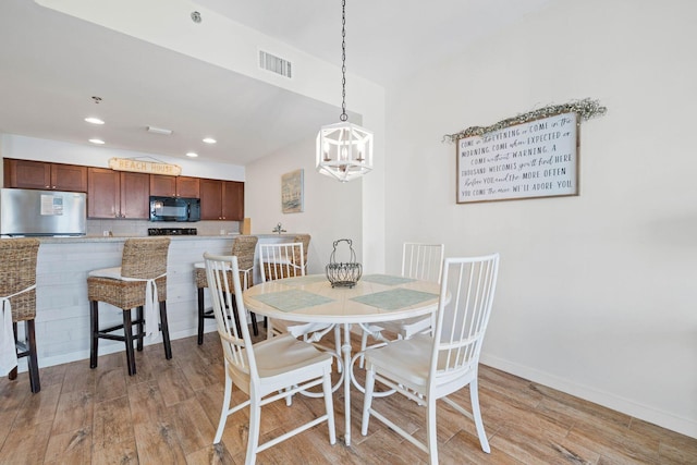 dining space with a notable chandelier, recessed lighting, visible vents, light wood-style floors, and baseboards