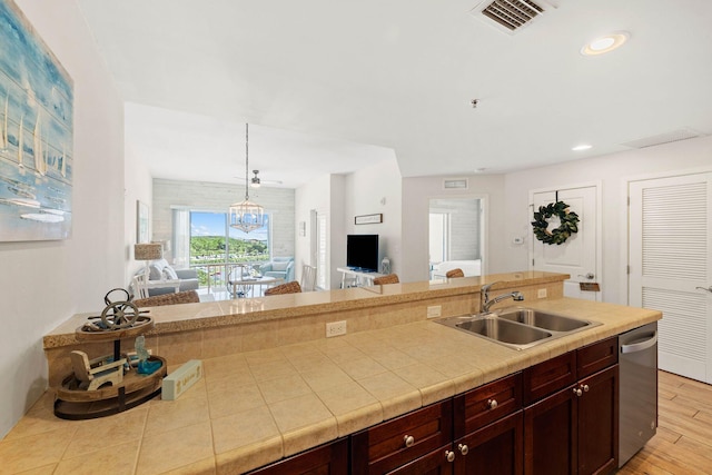 kitchen with light wood finished floors, light countertops, visible vents, a sink, and dishwasher