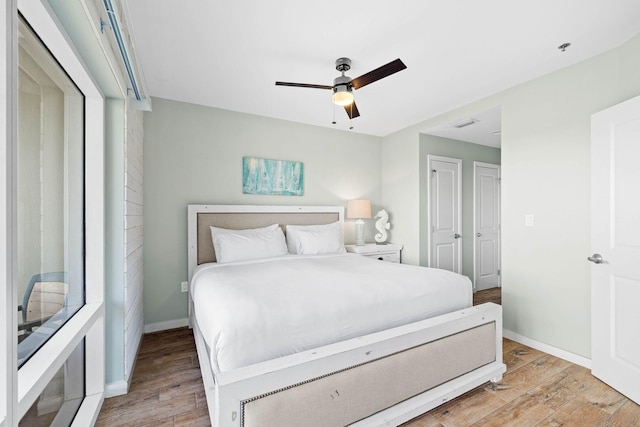 bedroom with light wood finished floors, ceiling fan, and baseboards