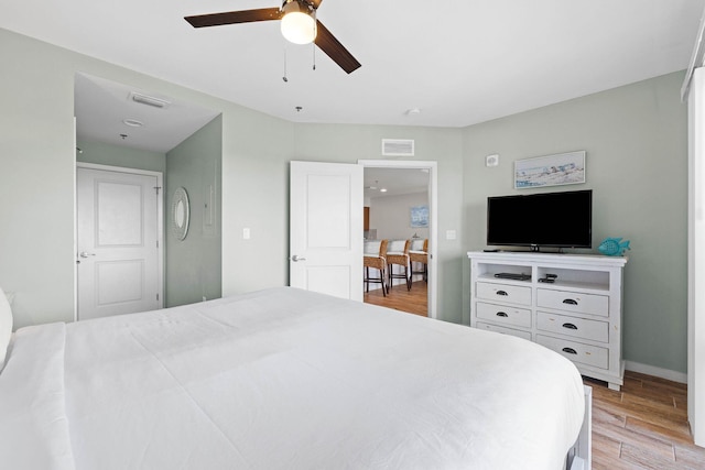 bedroom with visible vents, ceiling fan, light wood-style flooring, and baseboards