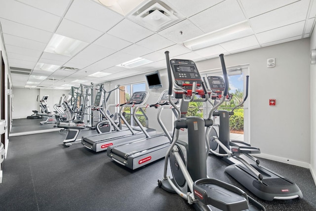 gym with visible vents, baseboards, and a drop ceiling