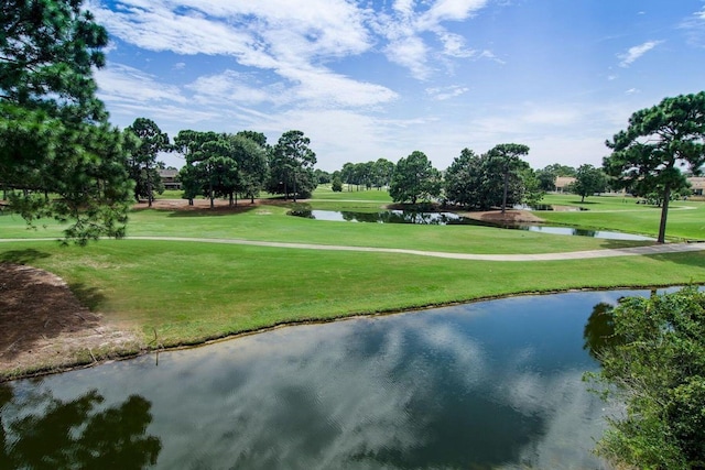 view of property's community with a yard, golf course view, and a water view