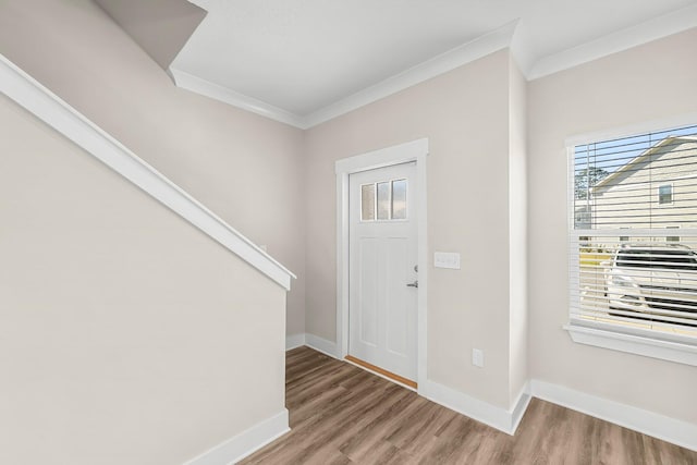 foyer with crown molding, baseboards, and wood finished floors