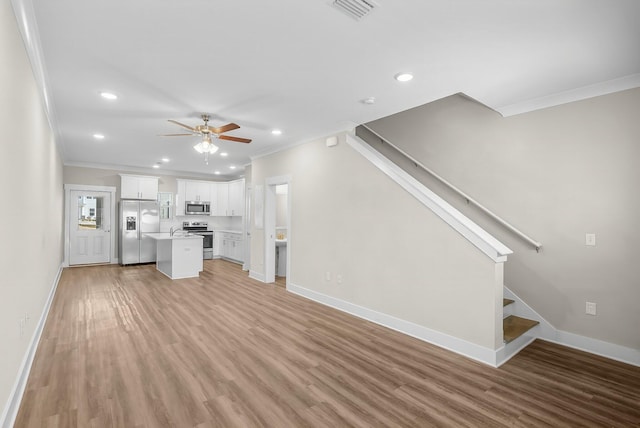 unfurnished living room with light wood-style flooring, baseboards, ceiling fan, and ornamental molding