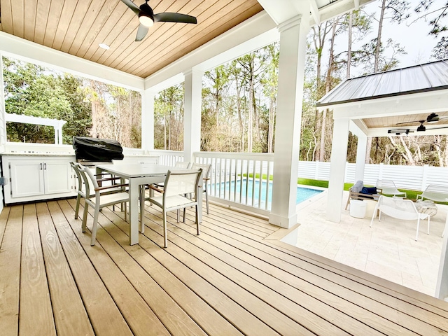 sunroom / solarium featuring ceiling fan and wooden ceiling