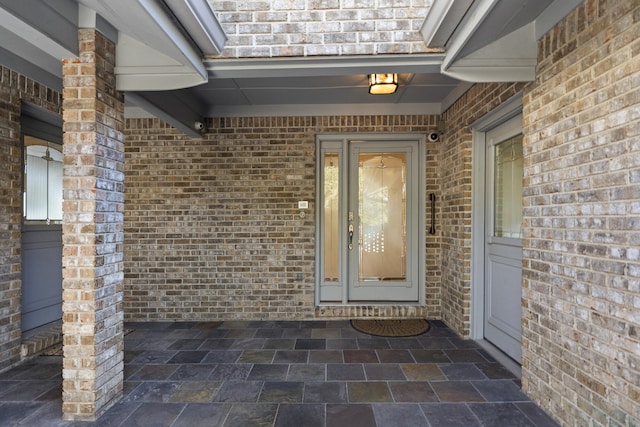 doorway to property featuring brick siding