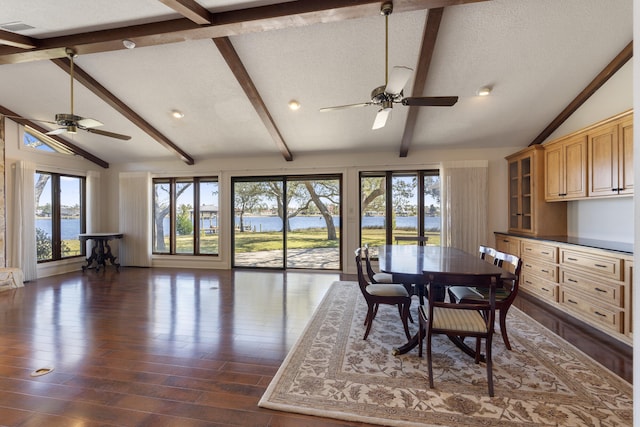 dining space with a textured ceiling, lofted ceiling with beams, dark wood-style floors, and ceiling fan