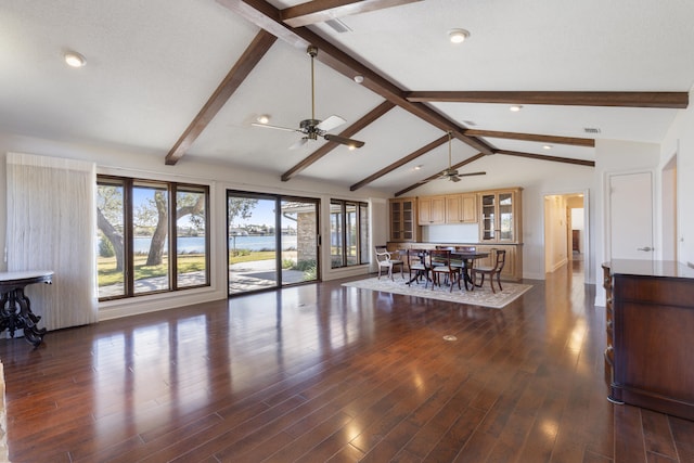 living room featuring visible vents, vaulted ceiling with beams, a ceiling fan, and wood finished floors