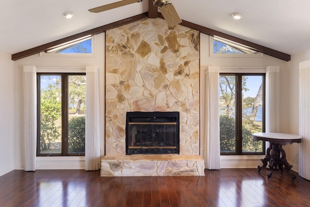 unfurnished living room with a healthy amount of sunlight, vaulted ceiling with beams, and hardwood / wood-style floors