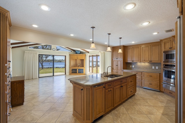 kitchen featuring visible vents, a sink, stainless steel appliances, a warming drawer, and tasteful backsplash