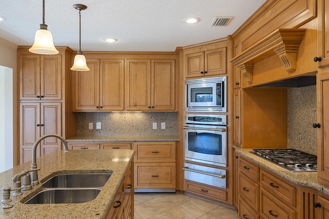 kitchen with visible vents, a sink, hanging light fixtures, stainless steel appliances, and a warming drawer