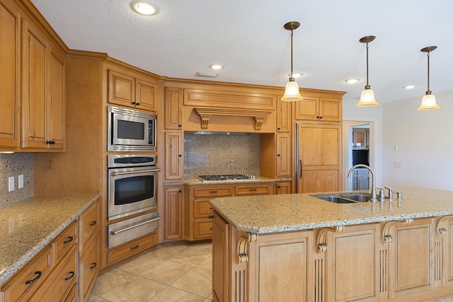 kitchen with visible vents, a sink, built in appliances, pendant lighting, and a warming drawer